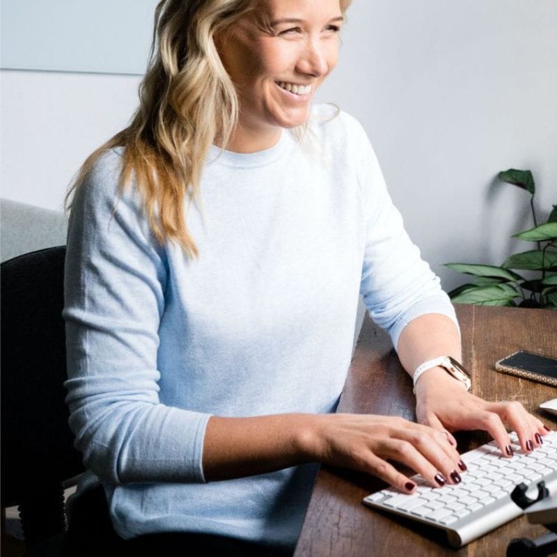 lab-testing-CTA Photo of health coach Jess completing a form on her computer while smiling
