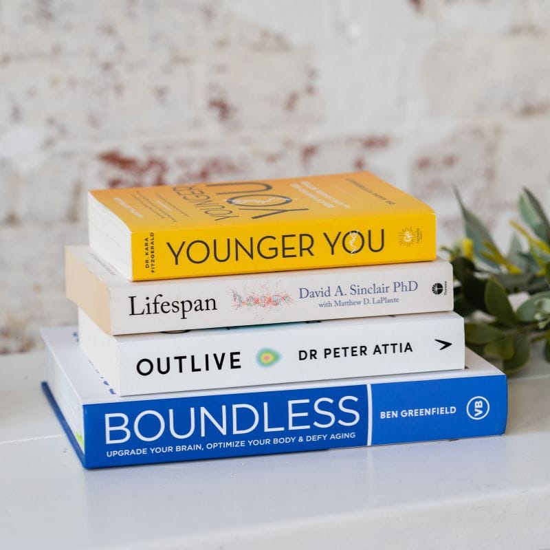 shipping-and-returns stack of health optimisation books on a white bench