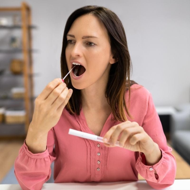 shop-mydna-comprehensive-9 A woman taking a cheek swab for a DNA test