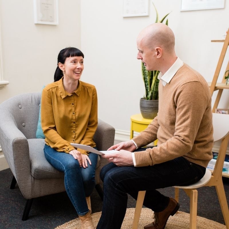 about-melbournes-best-functional-medicine-clinic practitioner jabe and health coach bee sitting on a couch discussing lab results.