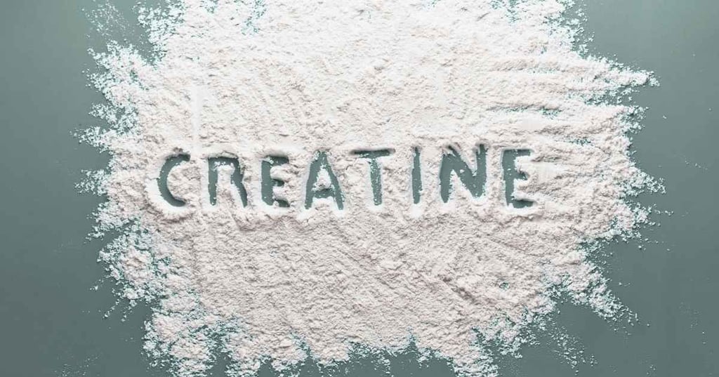 creatine power spread on aloe green bench with word creatine drawn in powder