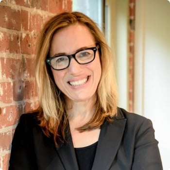dr-kara-fitzgerald woman leaning against brick wall smiling