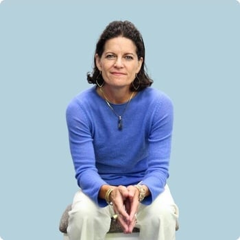dr-mindy-pelz woman in midlife sitting leaning forwards hands gently together