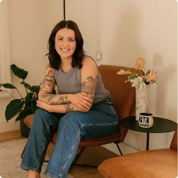greta-durston young woman sitting in leather armchair smiling