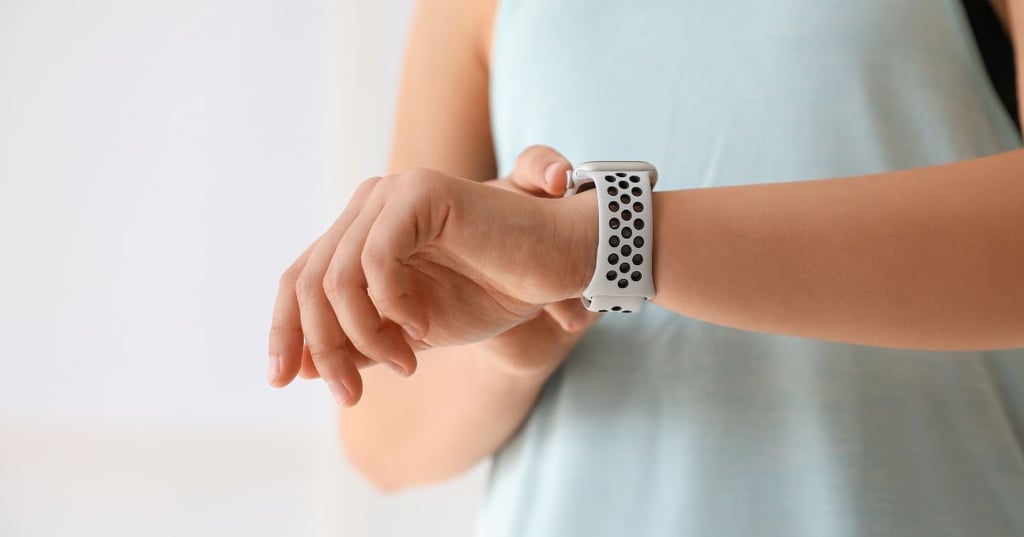 person wearing white health technology device watch on left wrist