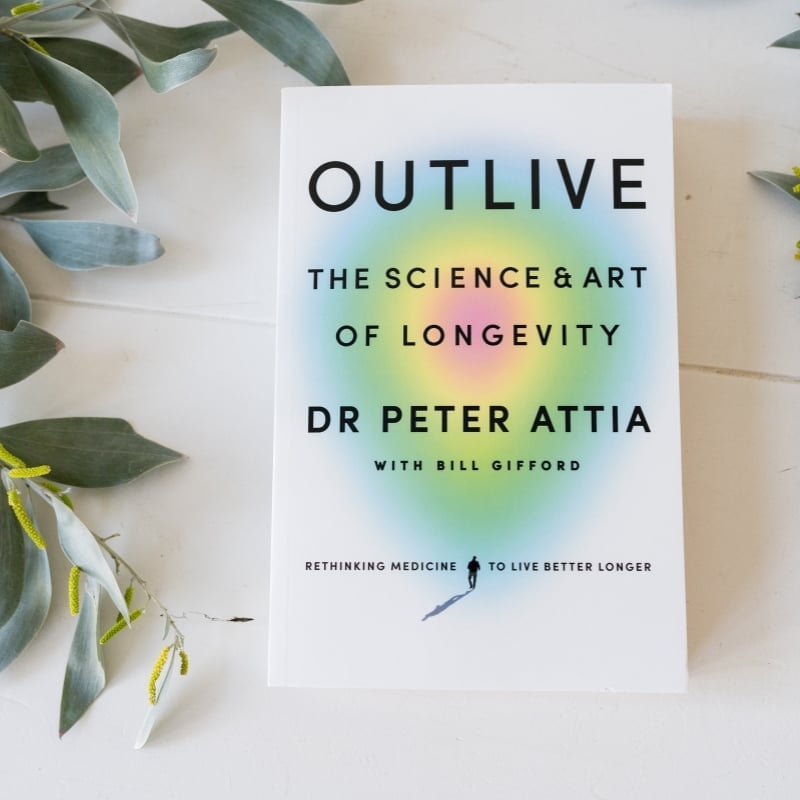outlive-dr-peter-attia-flatlay practitioner jabe and health coach bee sitting on a couch discussing lab results.