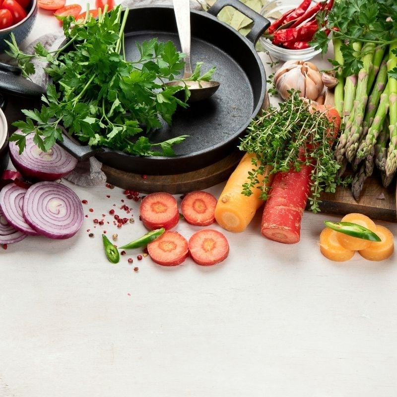 A white bench with a spread of colourful healthy whole food ready to be prepared