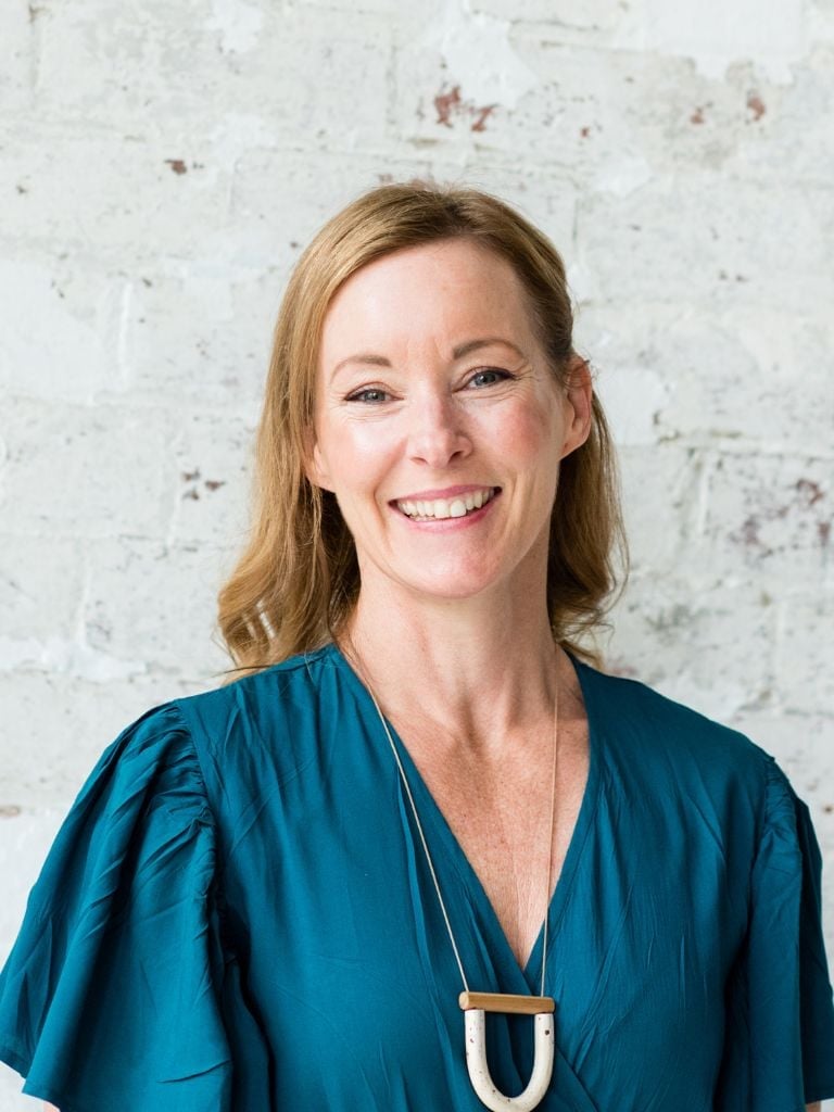 bee pennington health coach wearing teal dress standing smiling